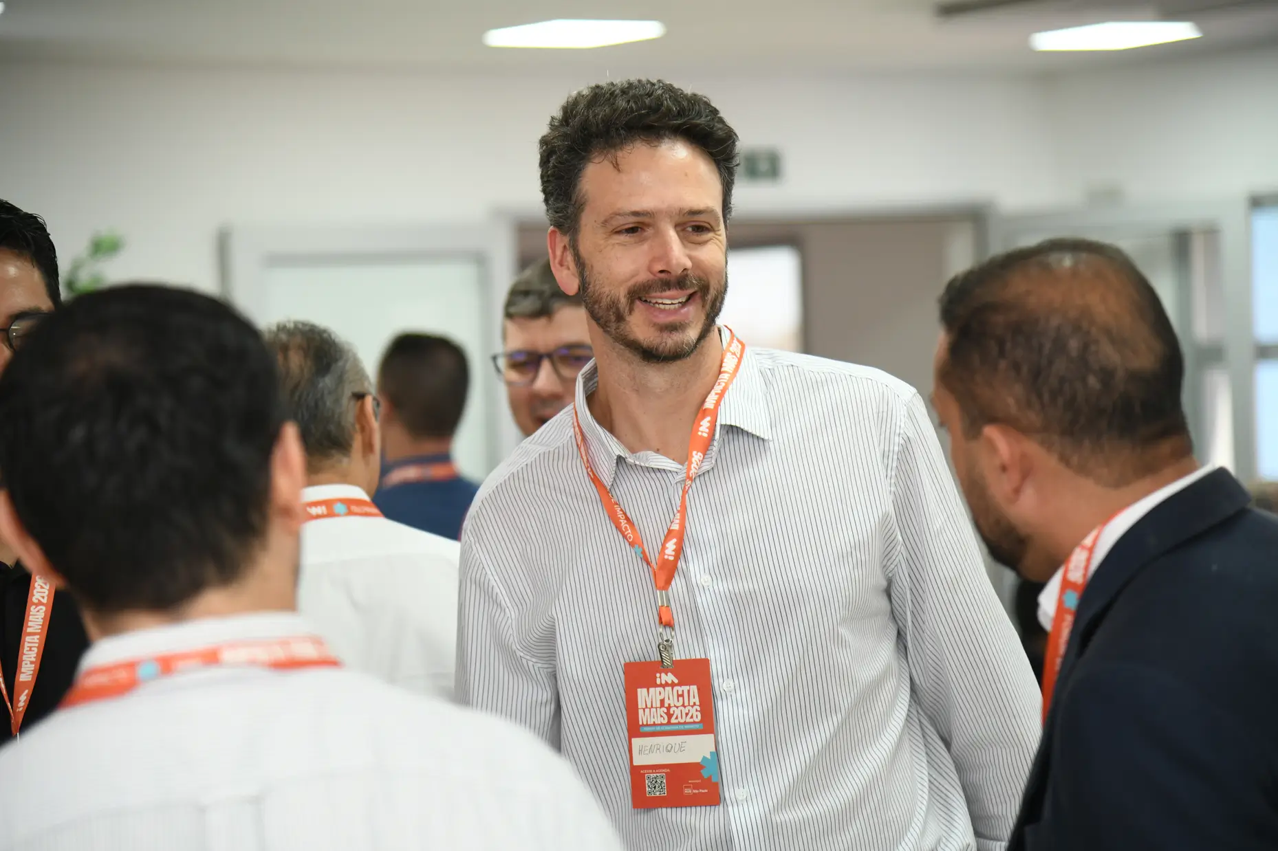 Jovem empreendedora sorri e estende o troféu de Destaque Demoday 2026 do programa Green Sampa, diante de um painel da marca